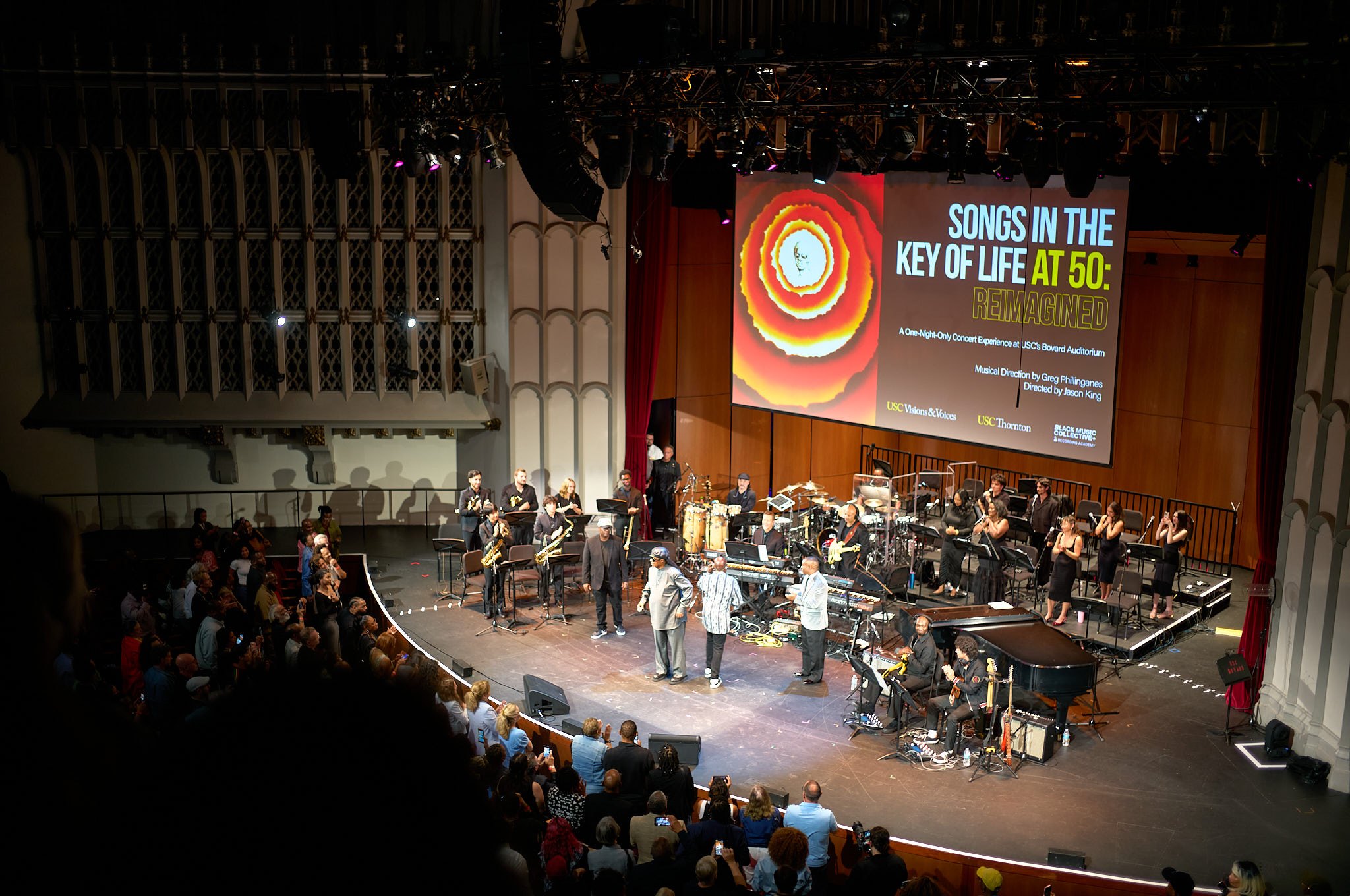 Stevie Wonder and the band on stage at Bovard Auditorium under the Songs in the Key of Life at 50 screen